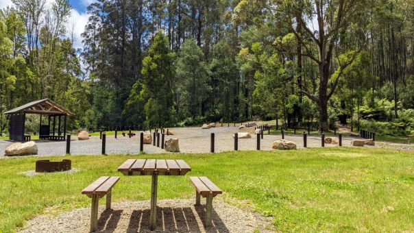 Picnic table at Checking Station. A green lawn and parking spaces near by.