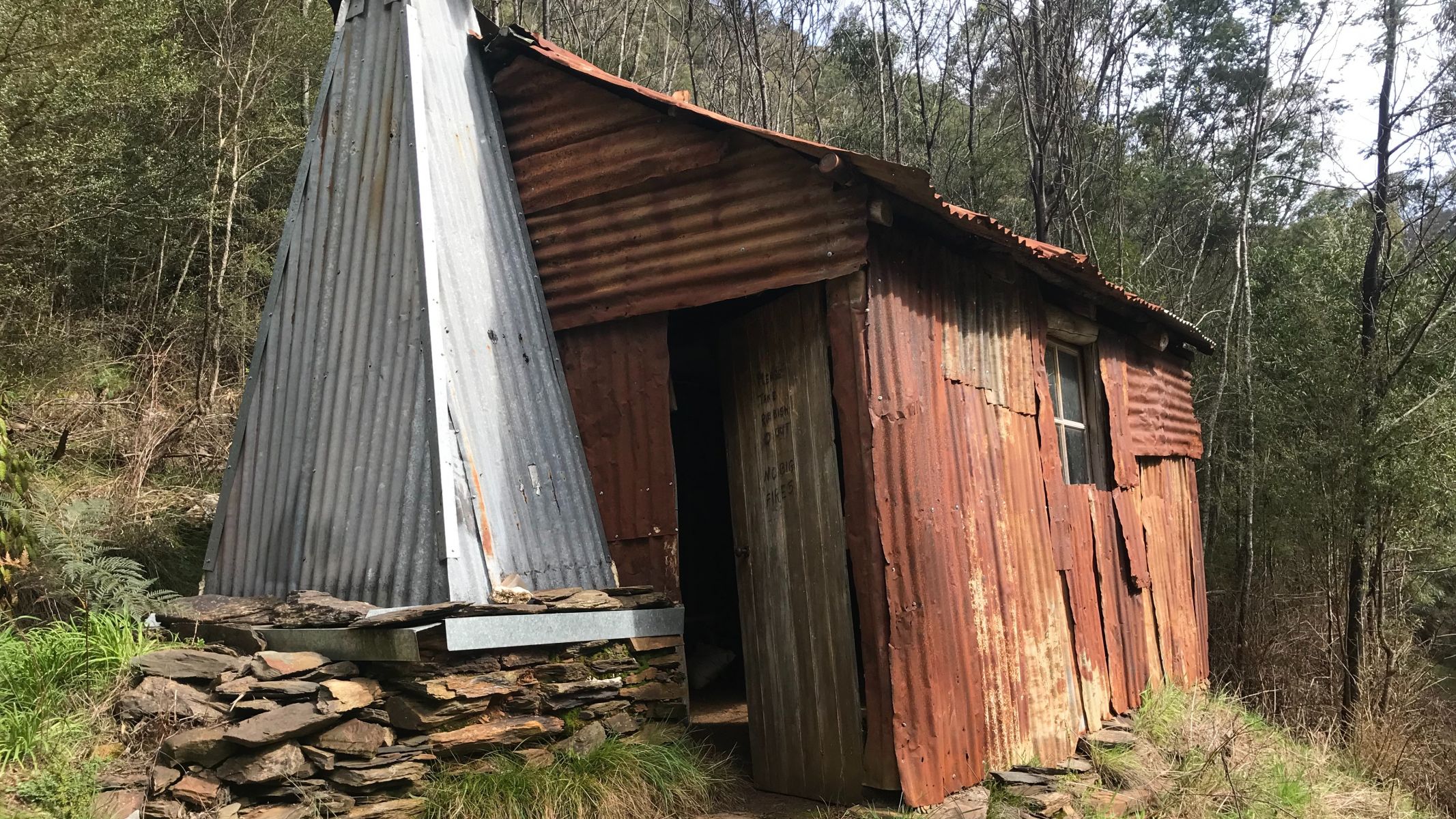 A rusted corrugated iron hut in the bush