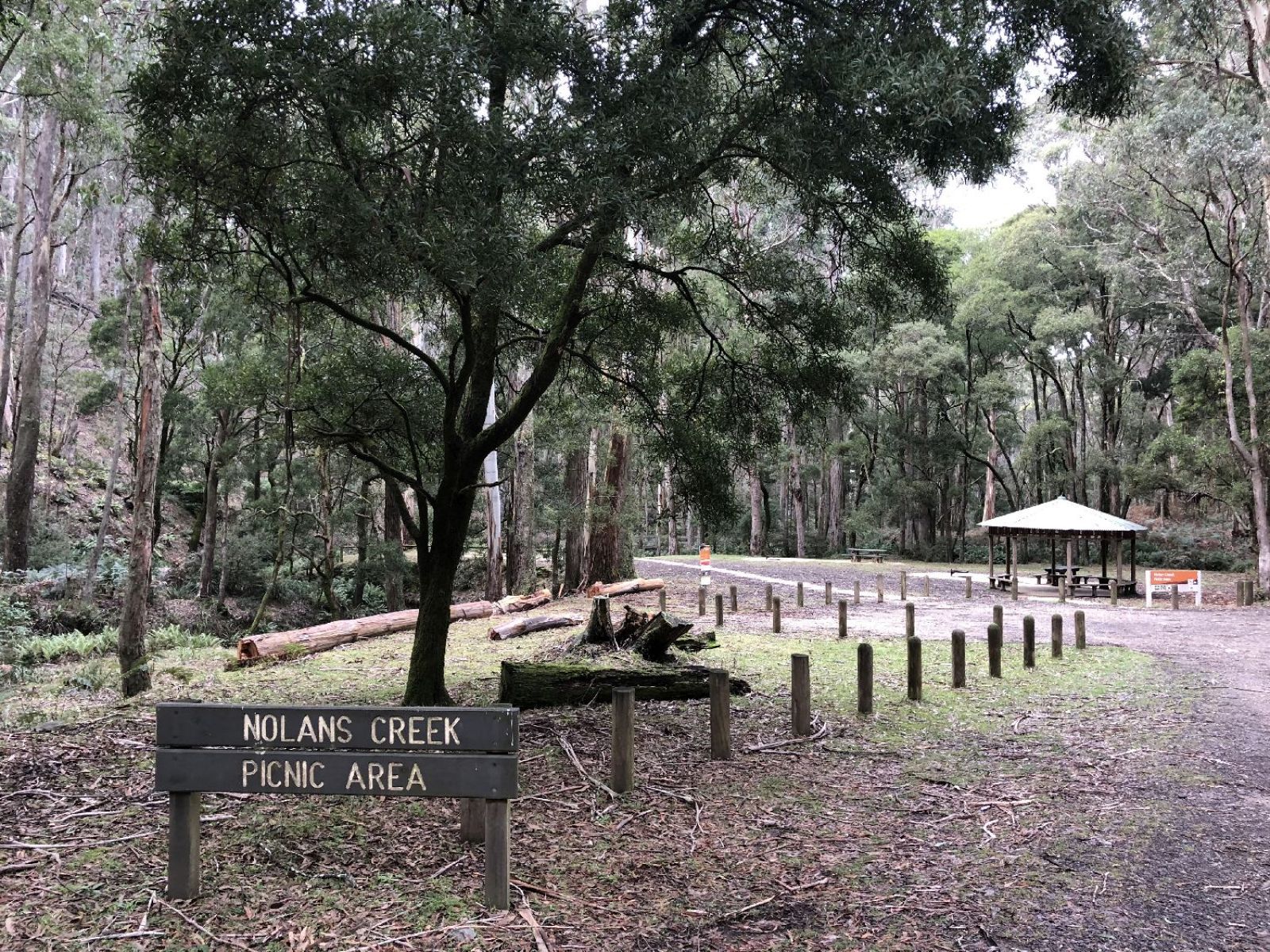 The entrance area to the Nolans Creek Picnic Area with Nolans Creek signage and the picnic shelter in the background. 