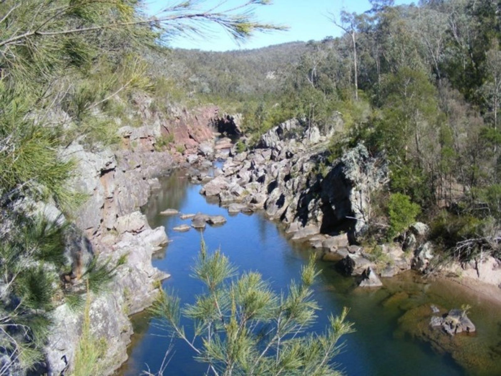 A river surrounded by a rocky gorge and green trees