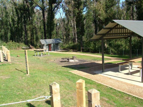 A picnic shelter and picnic tables on grass