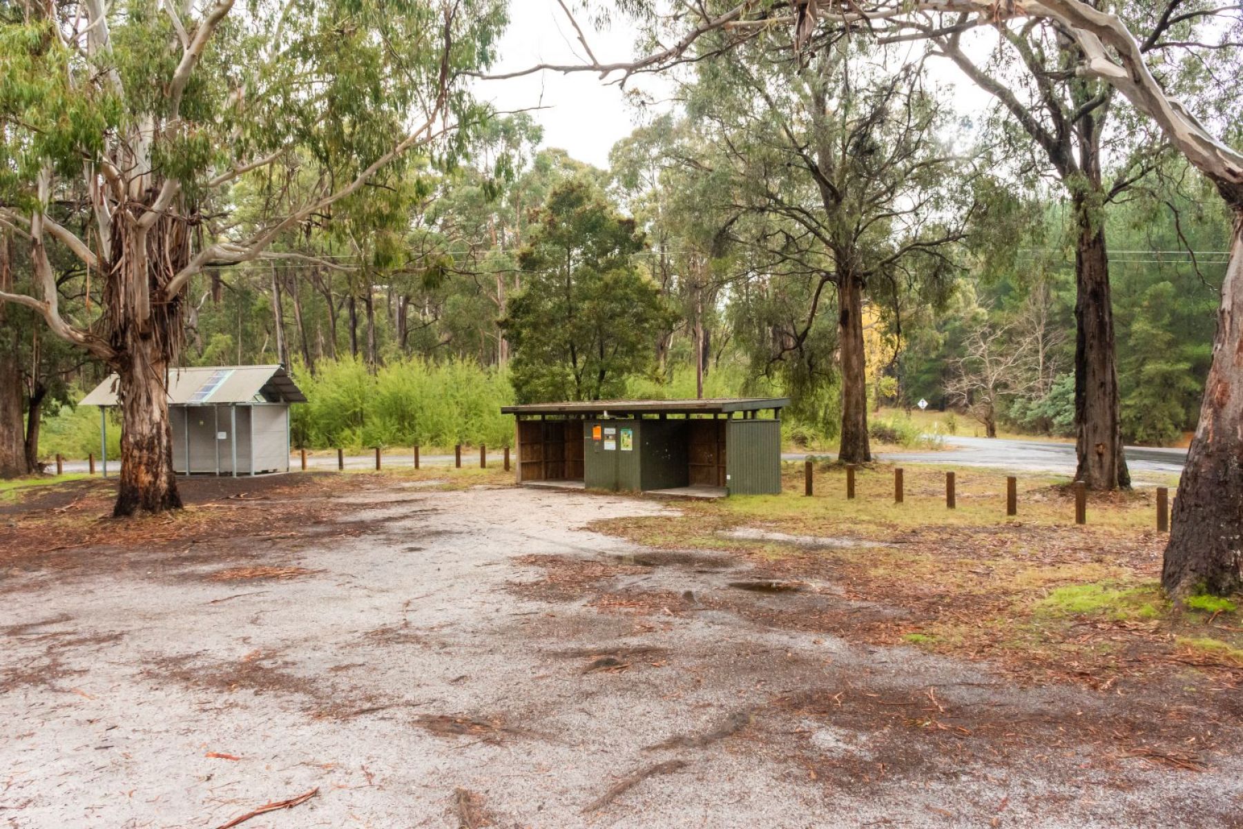 Open space for camping with picnic shelter and toilet in the background 