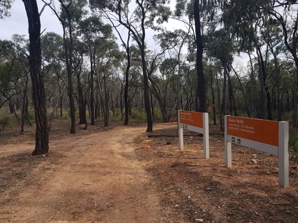 Two signage boards displaying nearby walking tracks from the Basin picnic ground.