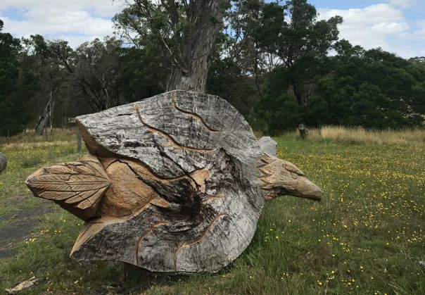 A fallen tree limb featuring carved animals