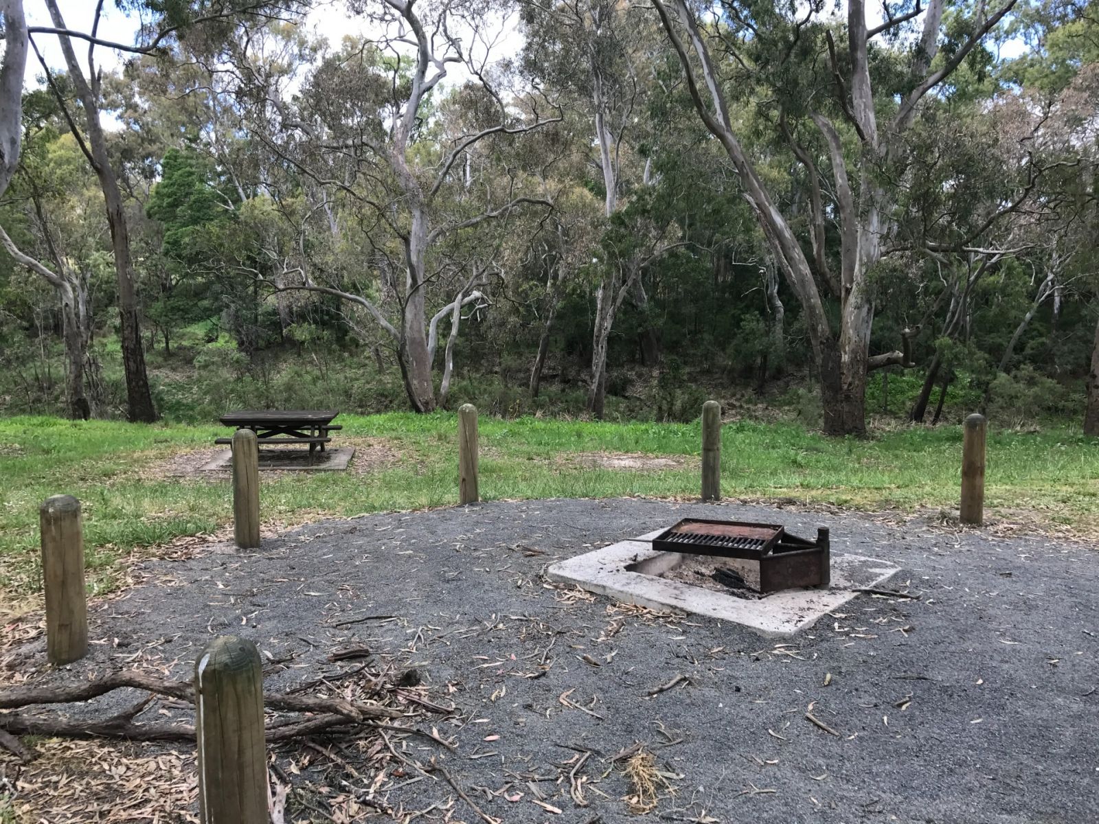 A wood-fired BBQ and picnic table