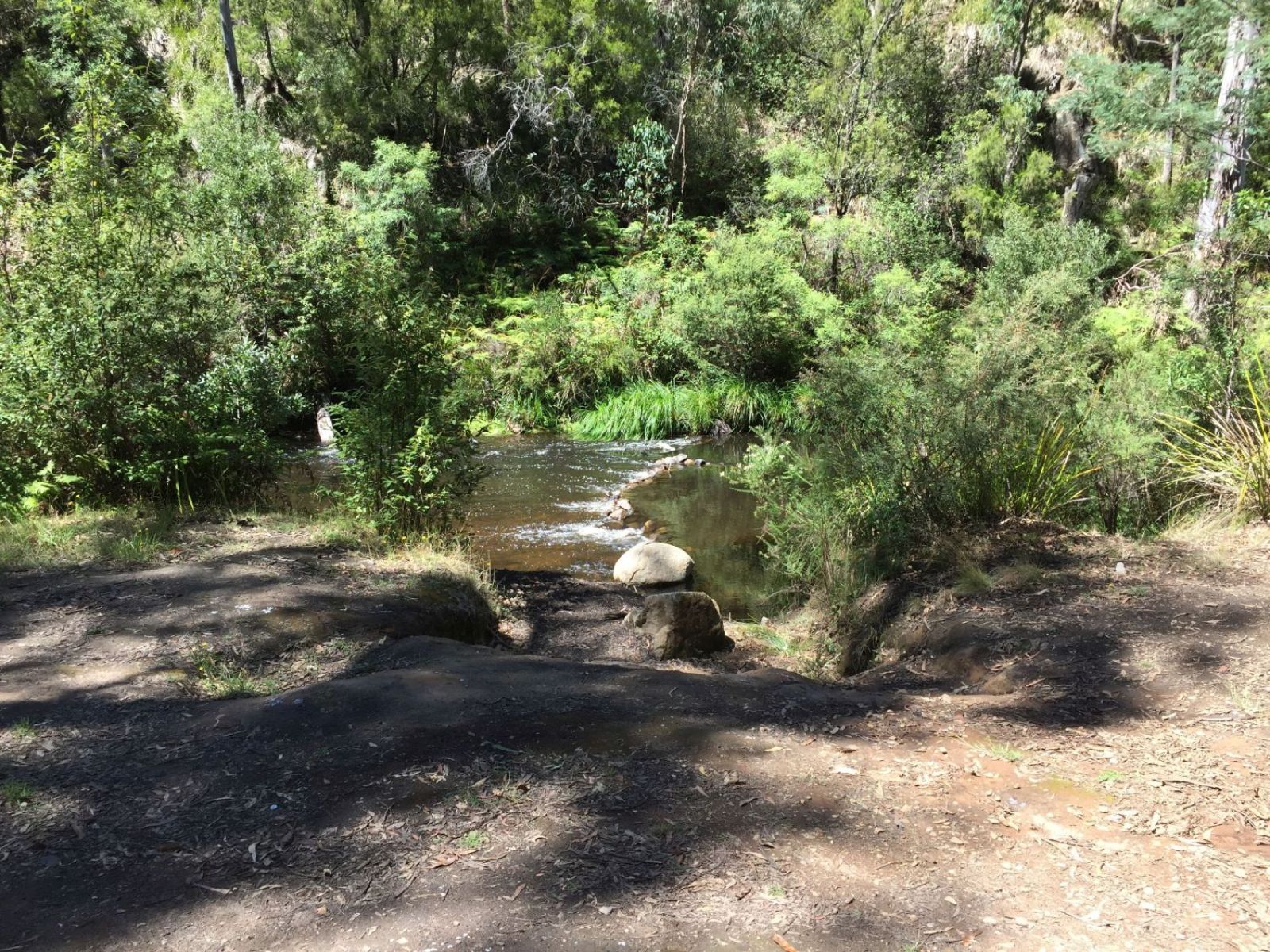 A small walkway leading down a few steps to a river