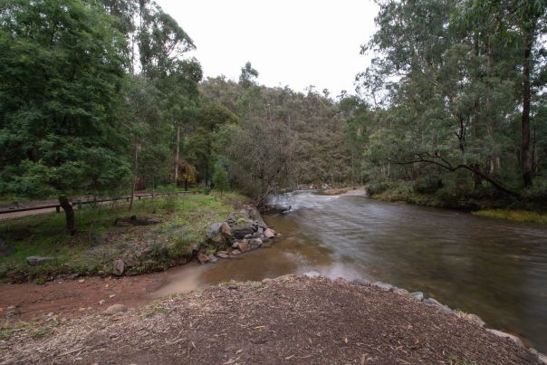 owqua River where you can fish. The river is surrounded by tall trees and there is a flat space in the foreground. 