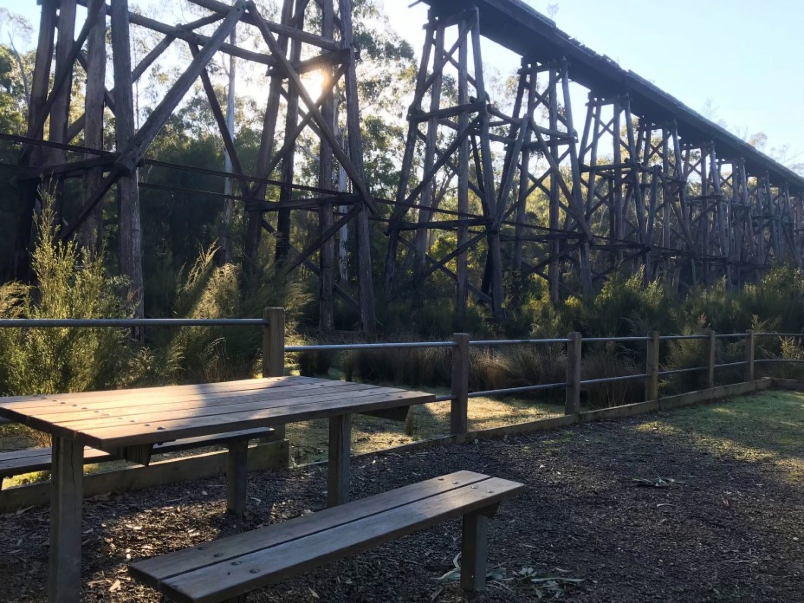 A picnic table at the base of the trestle bridge