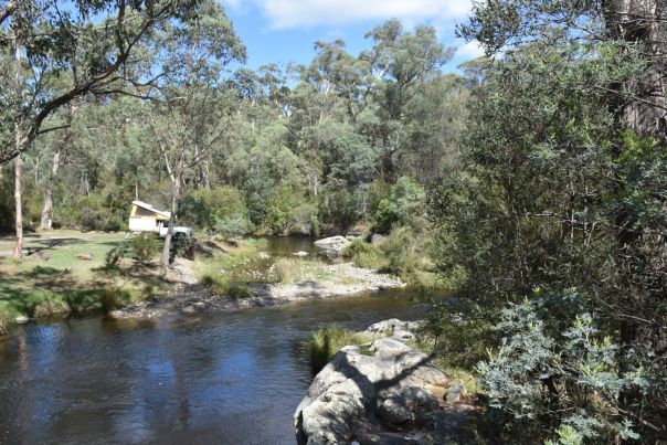 A campervan parked on a grassy area on a riverbank