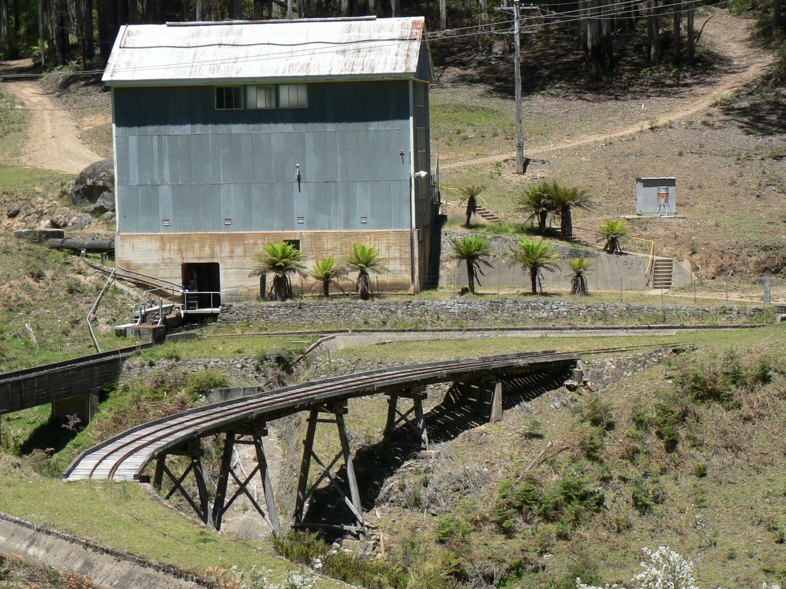 An old tin depot stands next to a tramway bridge