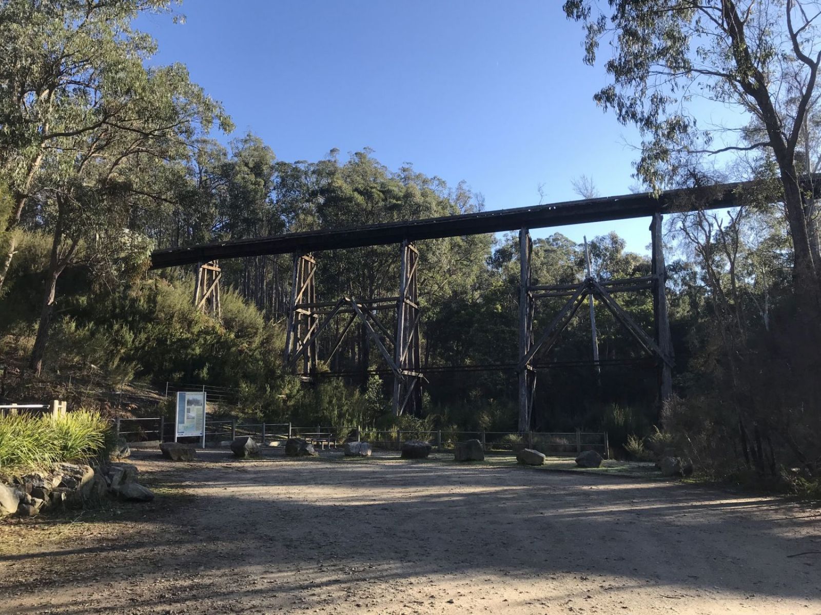 View of a trestle bridge on a sunny day in the bush.